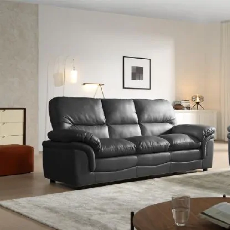 A three-seater black leather upholstery sofa in a minimalist living room.