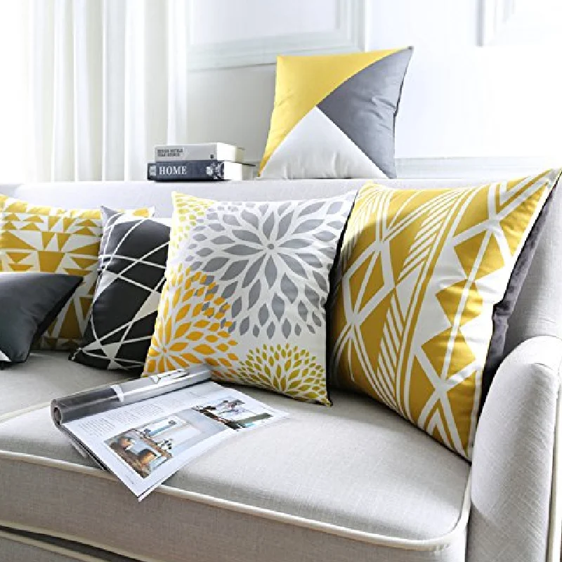Abstract floral and geometric print throw pillows in yellow and gray.