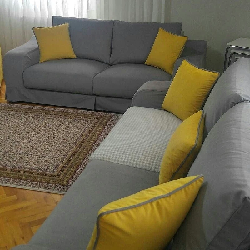 Gray sectional sofa with bright yellow cushion upholstery.