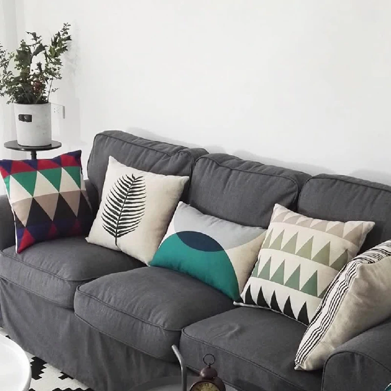 Various decorative cushions upholstery on a gray sofa.