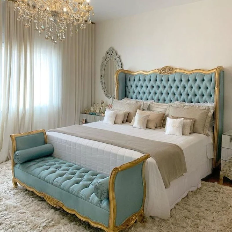 a well-maintained bedroom with an ornate blue and gold tufted headboard