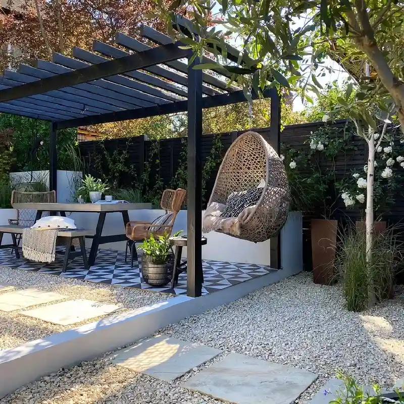 black custom-built pergola providing shade over a patio with a patterned tile floor