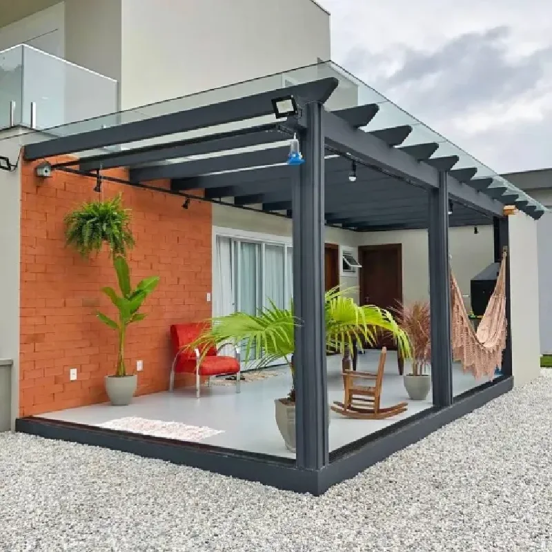 black custom pergola with a partial glass roof, providing shade over a modern patio