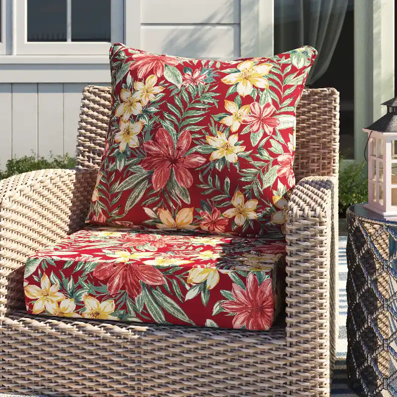 outdoor chair with a red, yellow, and green tropical floral outdoor cushion on the seat