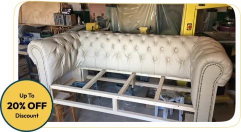 tufted leather sofa being repaired, with its wooden frame