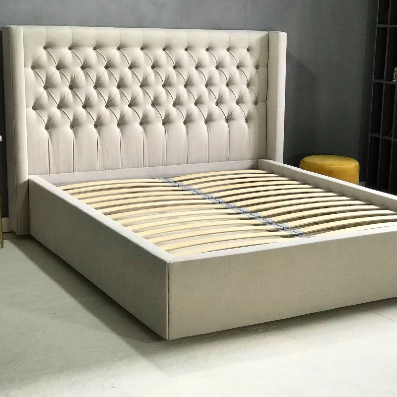 white, upholstered bed frame with a tufted headboard and wooden slats.