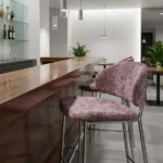 Dusty pink velvet bar stool at a wooden commercial bar