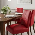 Red faux leather upholstered dining chairs at wooden table