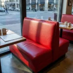 Red vinyl upholstered diner booth seating by restaurant window