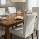 White faux leather upholstered dining chairs at wooden table